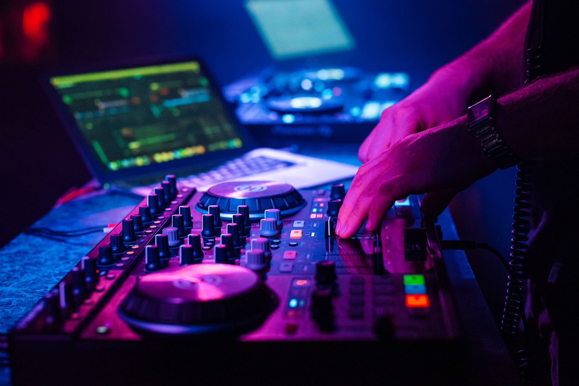 DJ mixes electronic music with his hands on a music controller